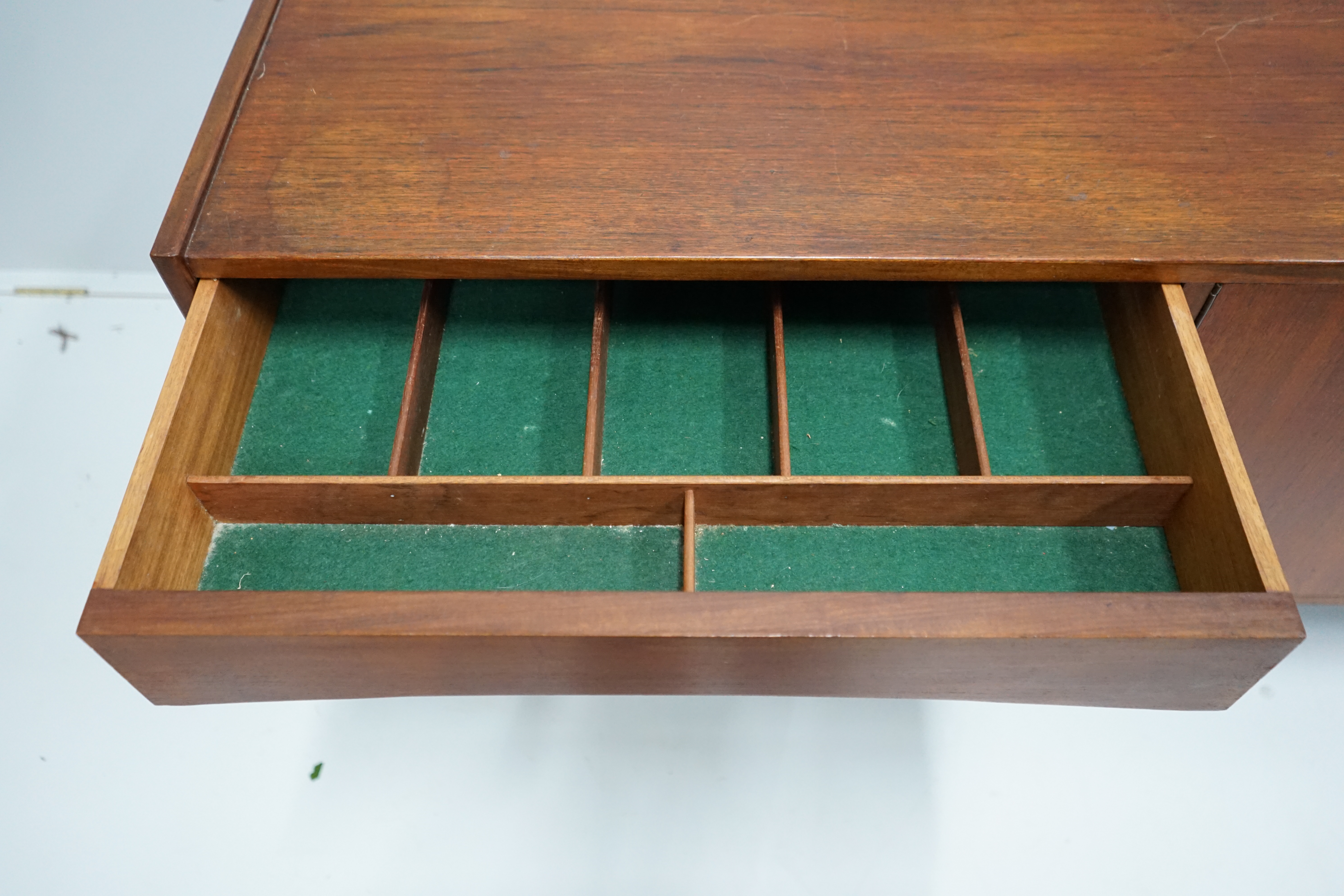 In the manner of Arne Vodder, a mid century teak sideboard width 221cm, depth 45cm, height 73cm.